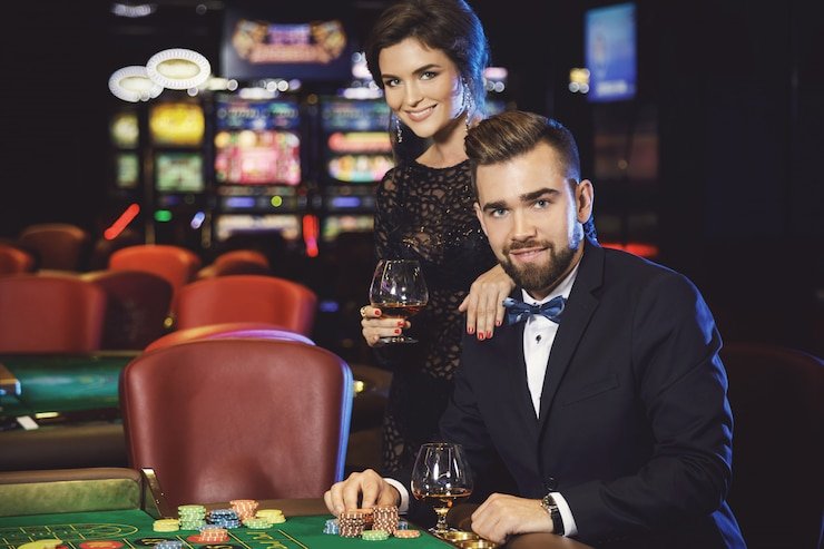 Dealer profesional jajantogel berdiri di sebelah roda roulette dalam studio live berkualitas tinggi
